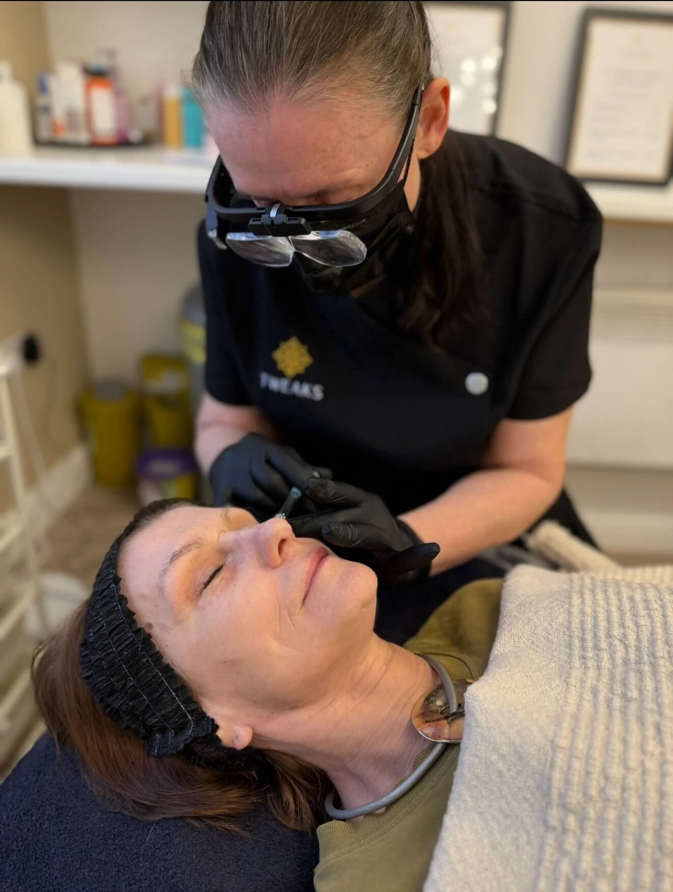 Professional esthetician performing facial treatment on client in modern spa setting
